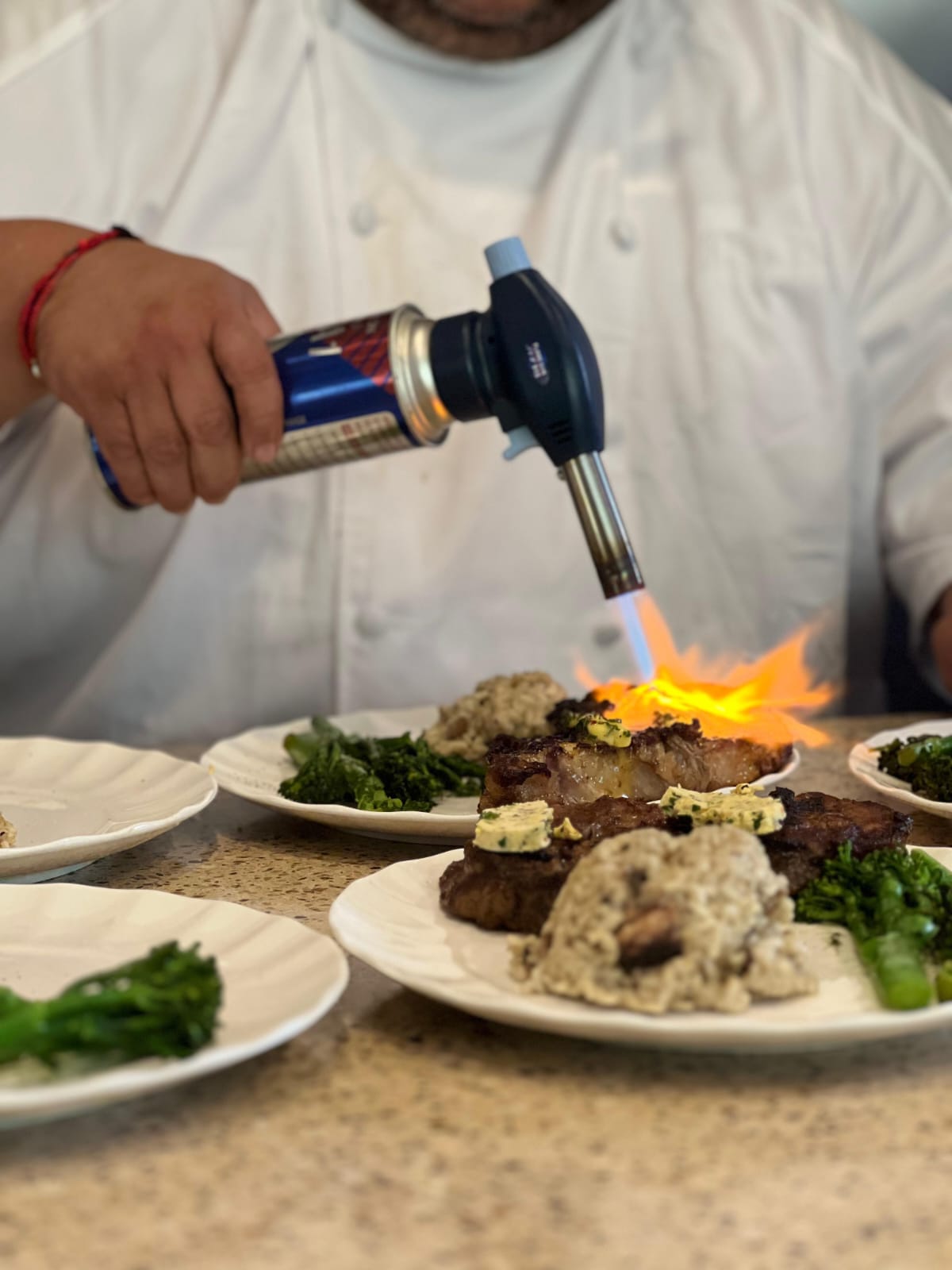 Chef flameando un plato — NutriBox Eventos